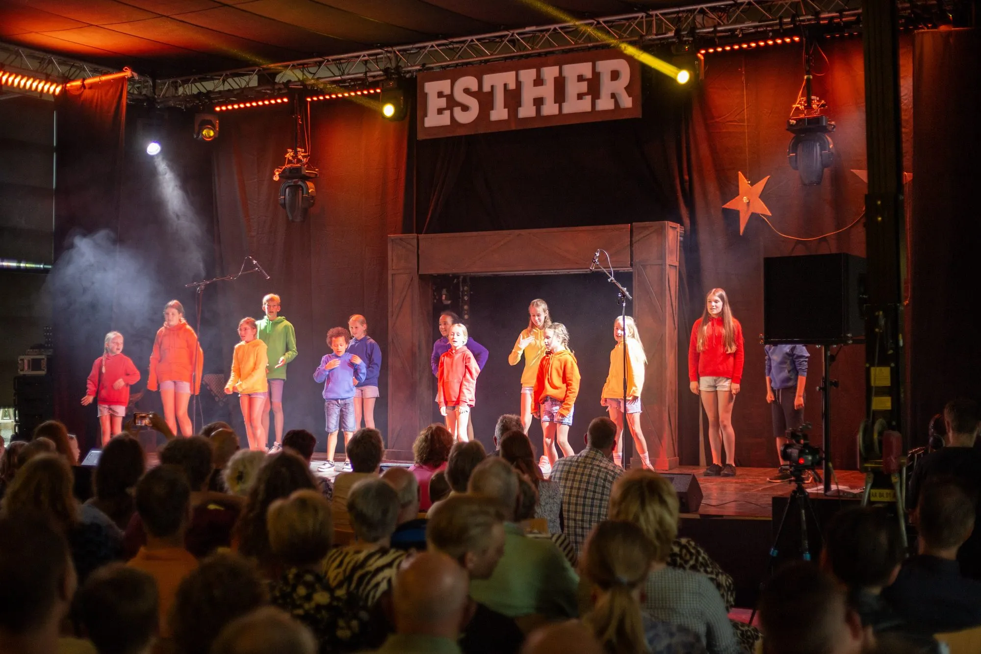 Kinderen in kleurrijke kostuums dansen op het podium