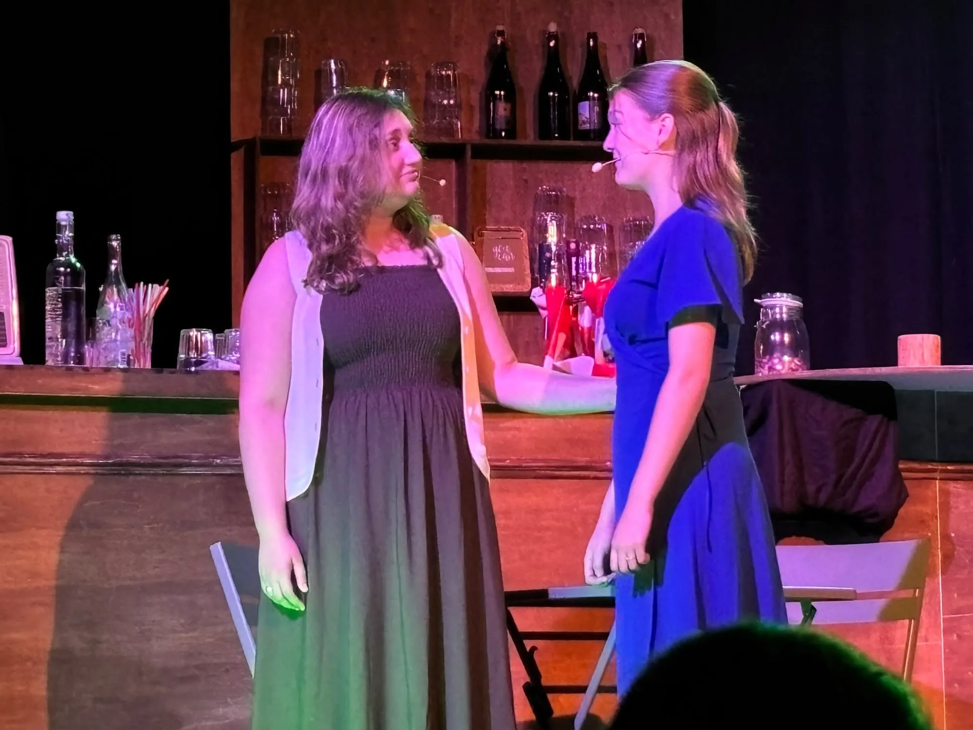 Twee vrouwen in gesprek bij een bar op het podium van Ruth