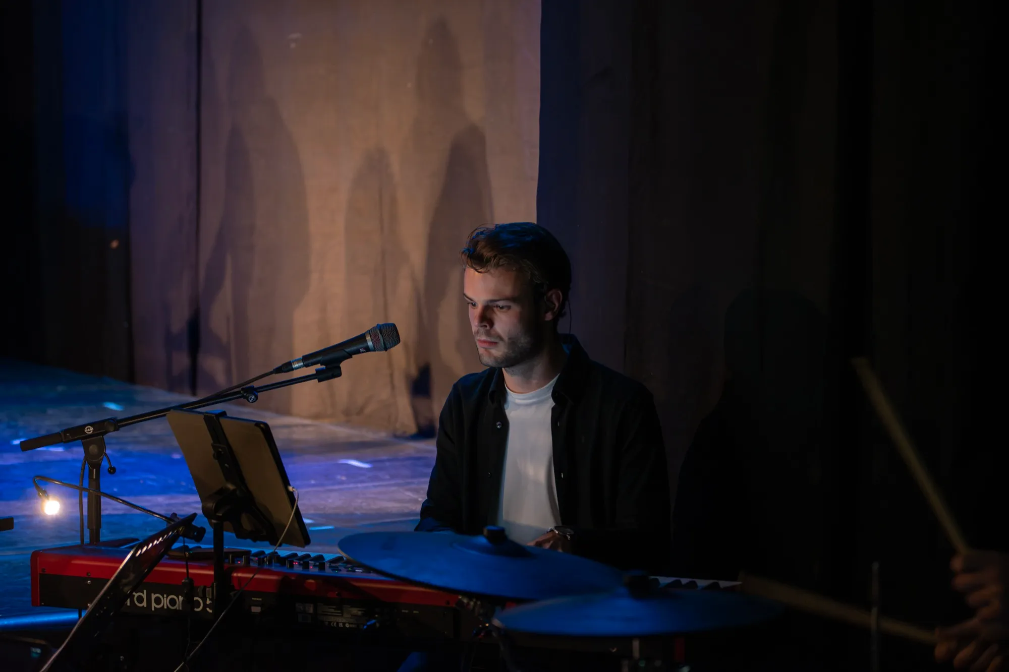 De toetsenist van de musicalband in het halfdonker
